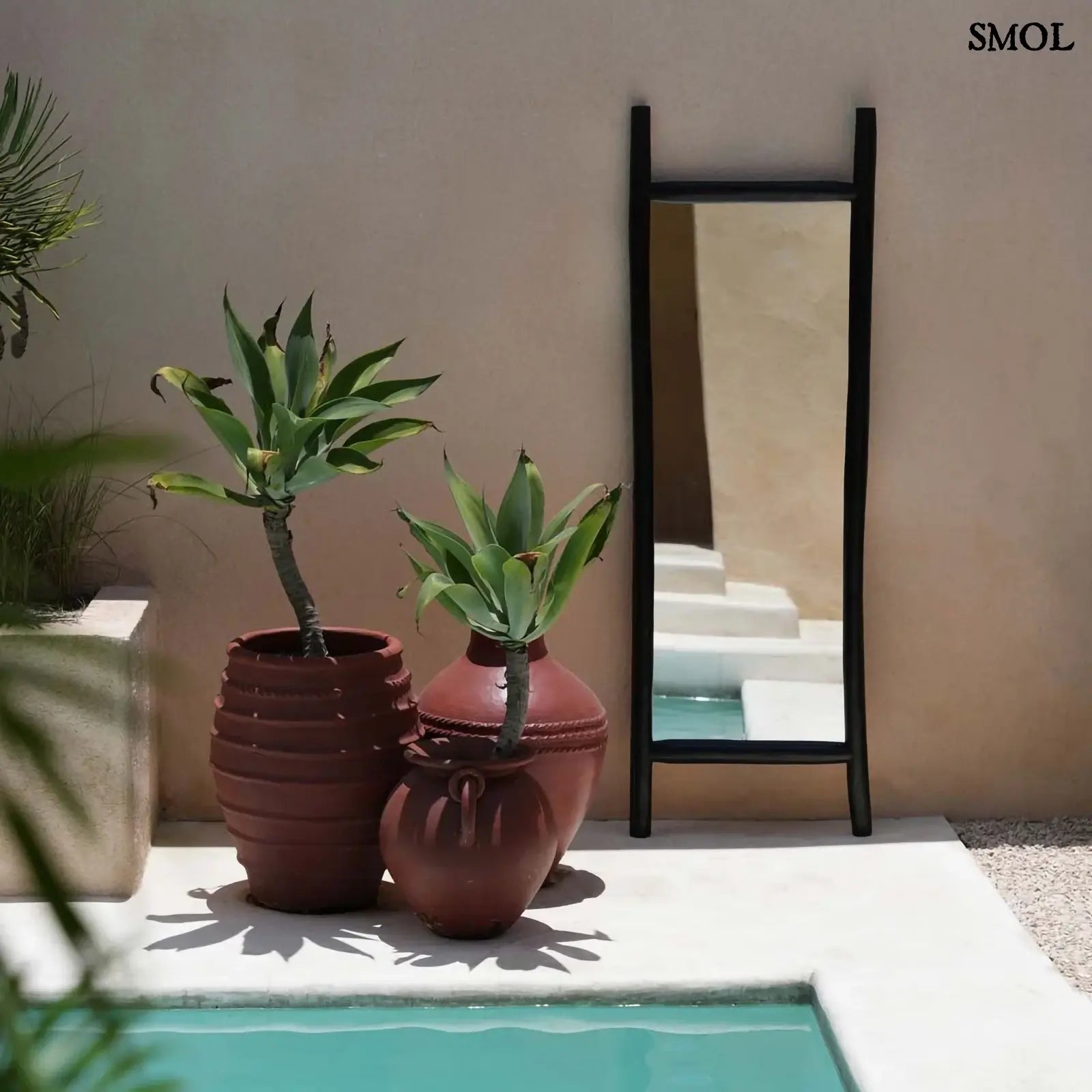 állótükör fekete teakfa keretben medence mellett kaspókkal