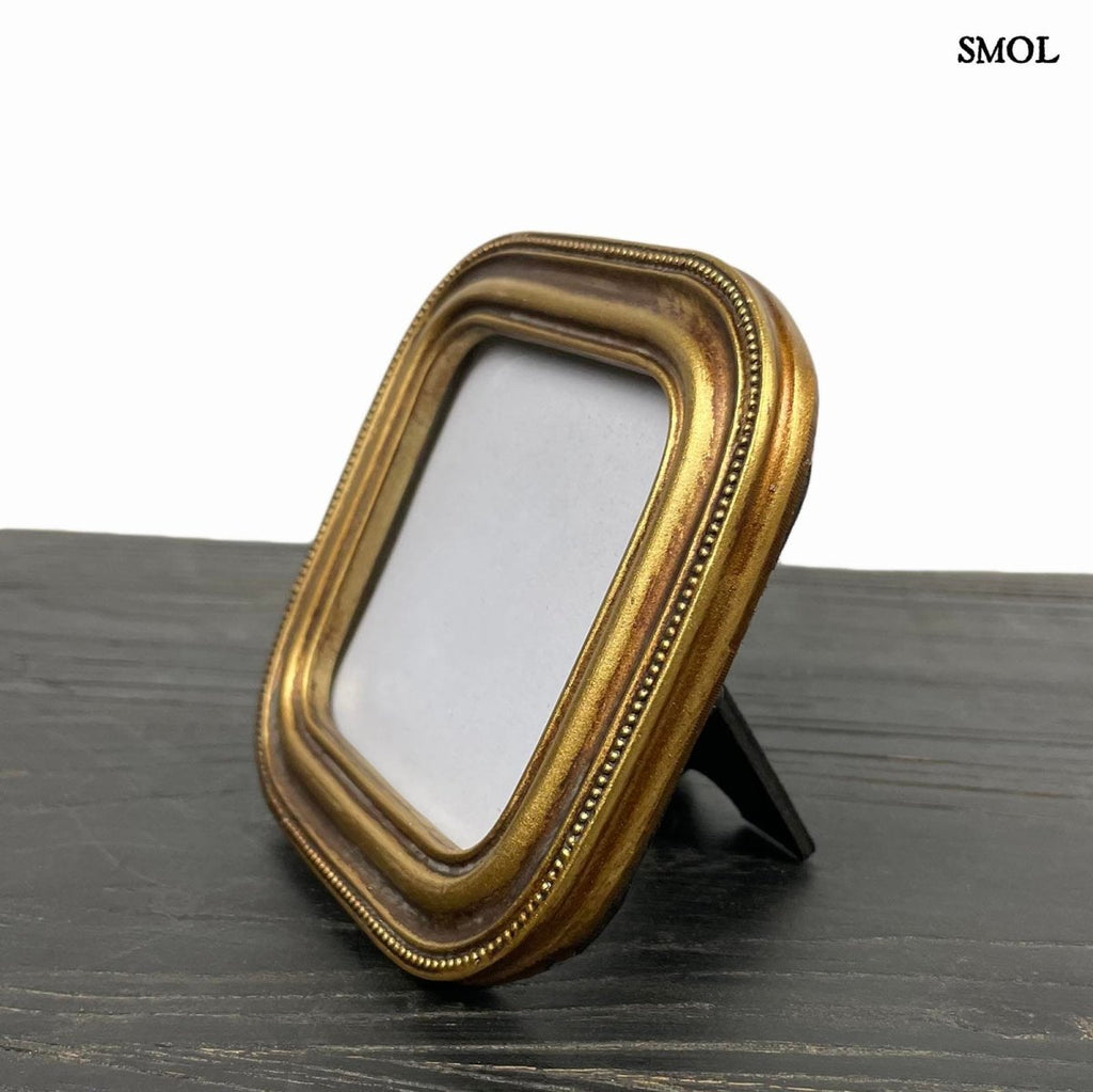 Antik arany képkeret kerekített sarkokkal és gyöngysoros díszítéssel, ferdén