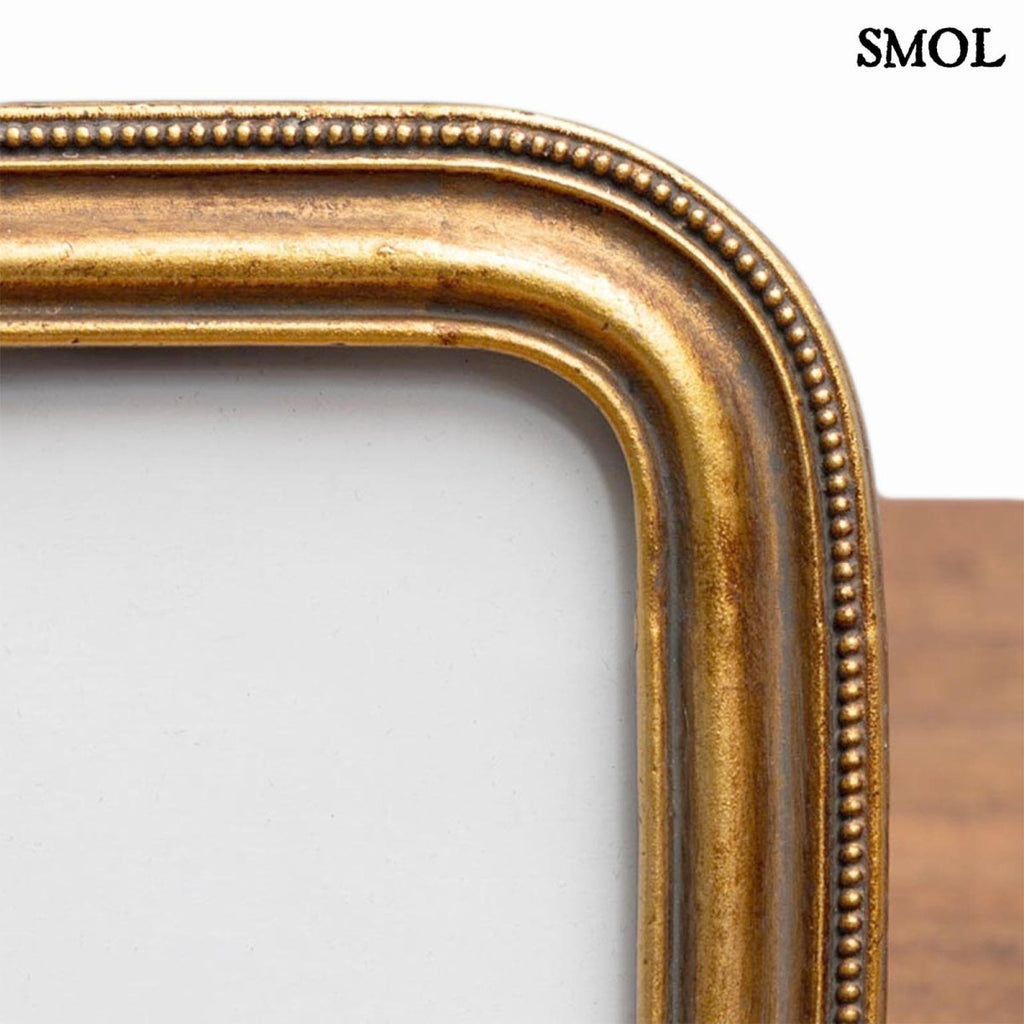 Antik arany képkeret kerekített sarkokkal és gyöngysoros díszítéssel, nagyítva