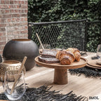 Arany gyertyatartó perforált mintával, meleg fényhatással étkezőasztalon