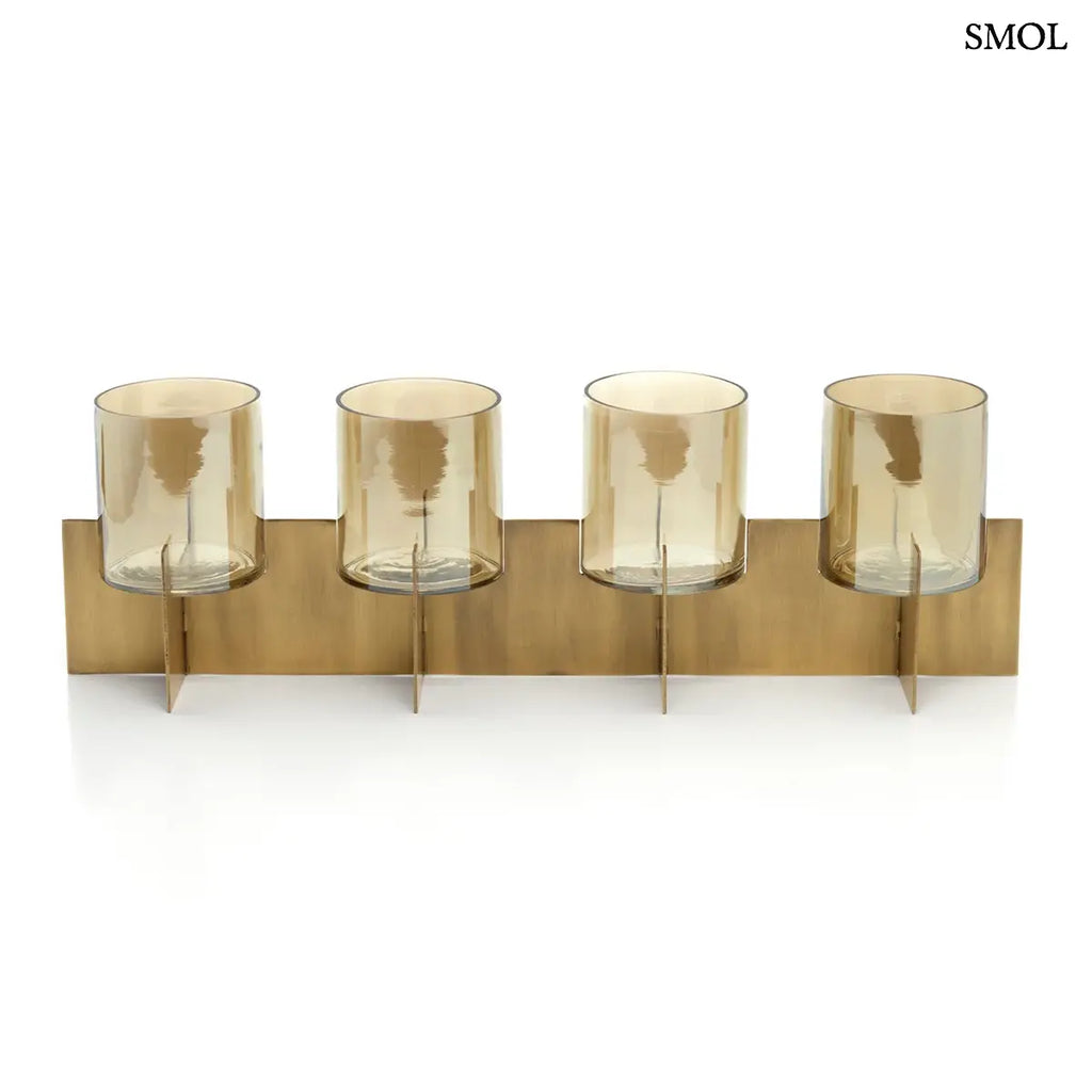 Modern, négyrészes asztali gyertyatartó antikolt sárgaréz vázban, borostyánszínű üvegpoharakkal, szemből