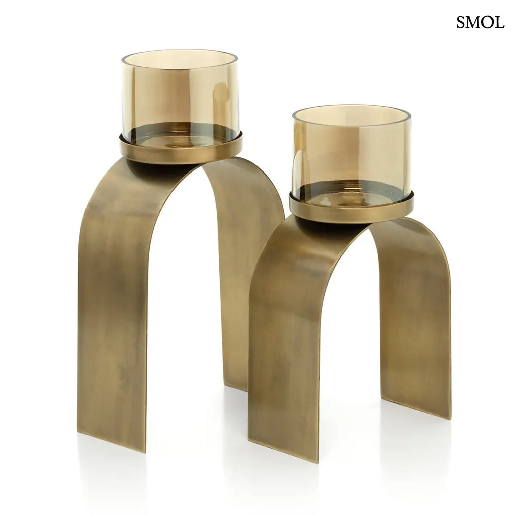 Arany mécsestartó szett két különböző méretű, íves sárgaréz tartóval és borostyánszínű üveggel, fehér háttérrel