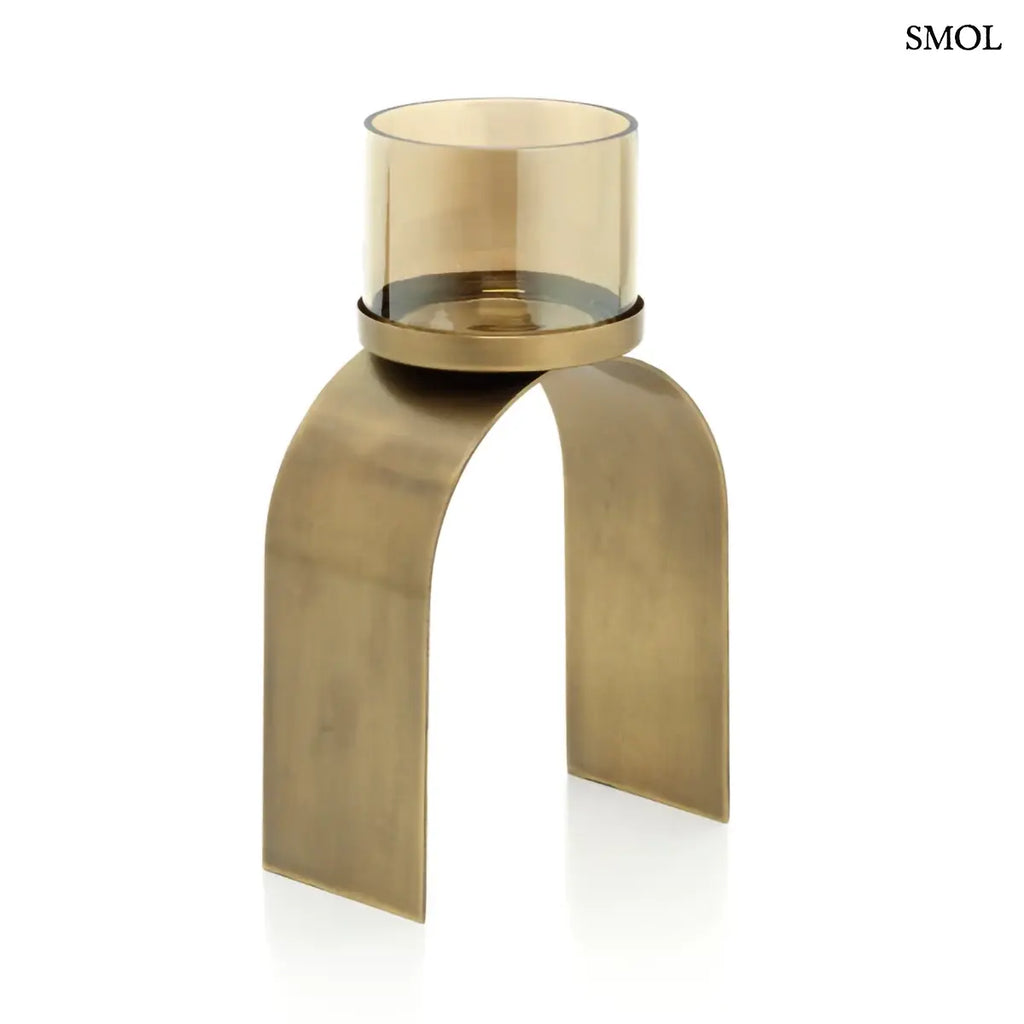 Arany mécsestartó szett két különböző méretű, íves sárgaréz tartóval és borostyánszínű üveggel, alacsonyabb mécsestartó fehér háttérrel