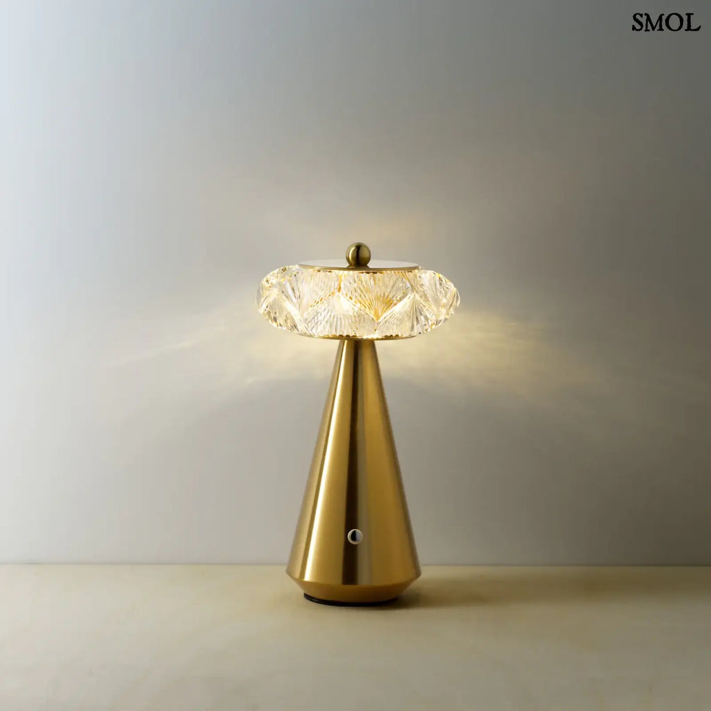 Arany színű, kúpos talapzatú, modern asztali lámpa meleg fénnyel