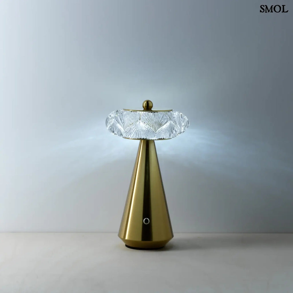 Arany színű, kúpos talapzatú, modern asztali lámpa lágy fénnyel
