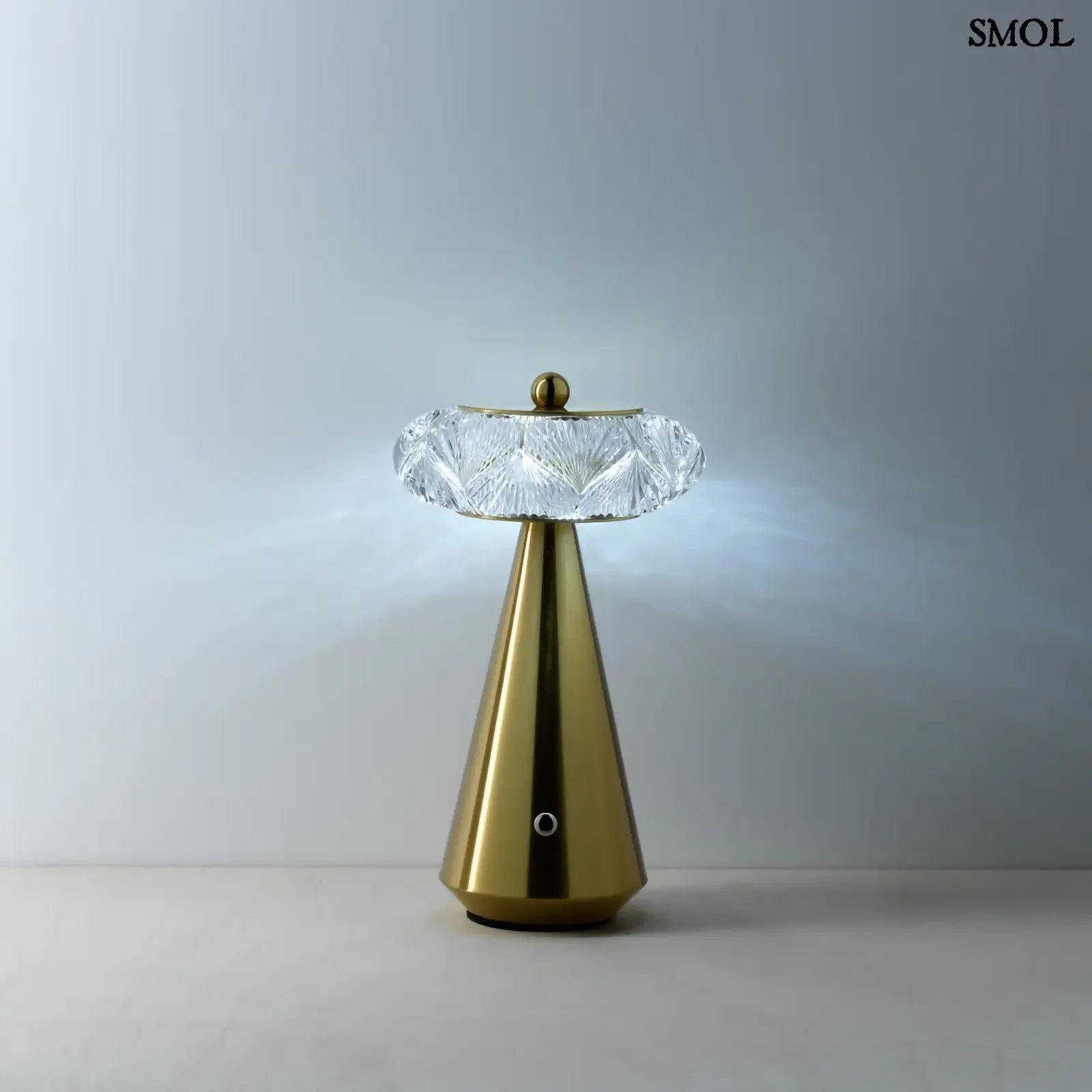 Arany színű, kúpos talapzatú, modern asztali lámpa lágy fénnyel