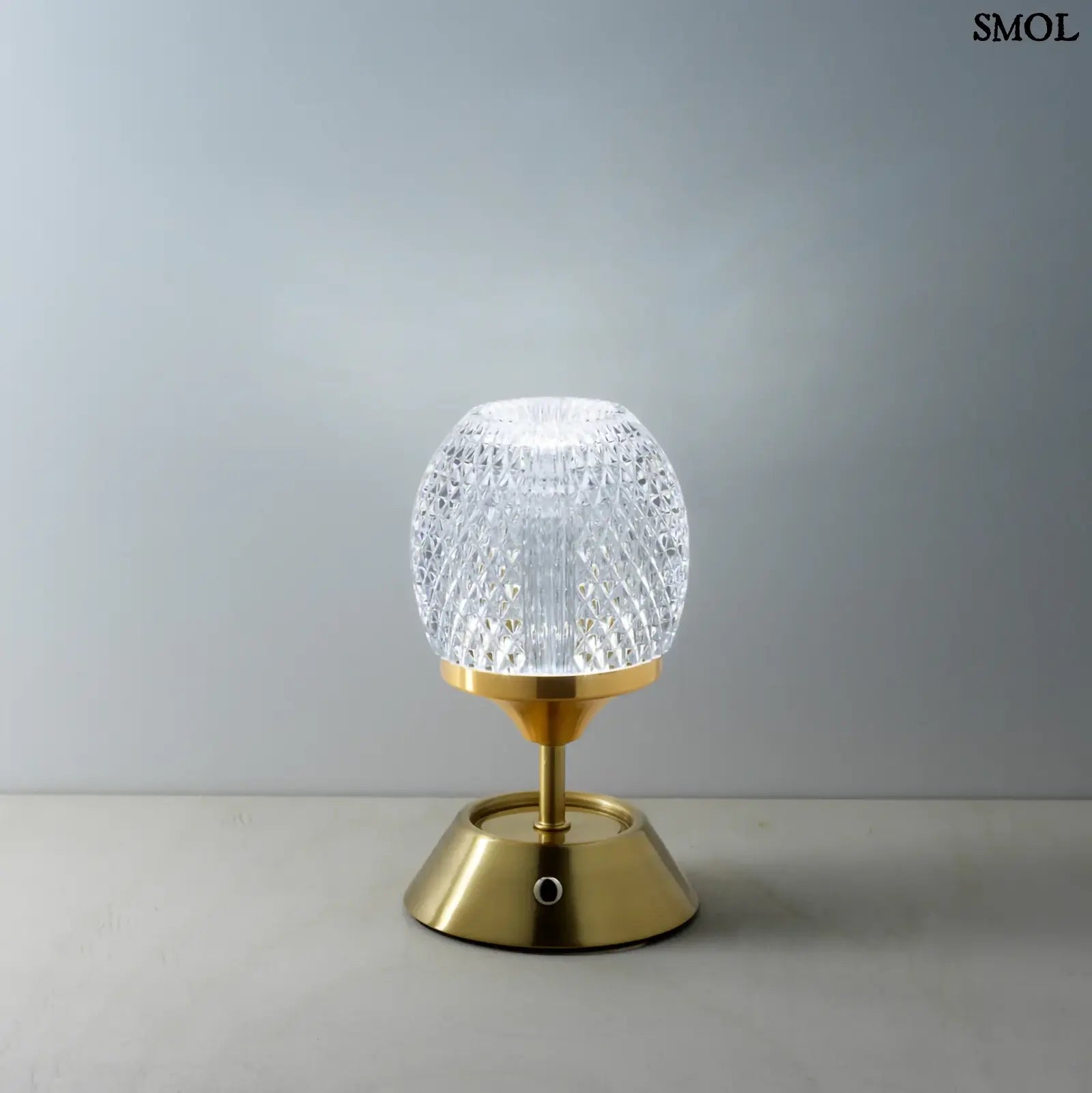 Sárgaréz talpú, kristályhatású, fazettált üveg búrával ellátott, hordozható, tölthető LED asztali lámpa szürke háttérrel