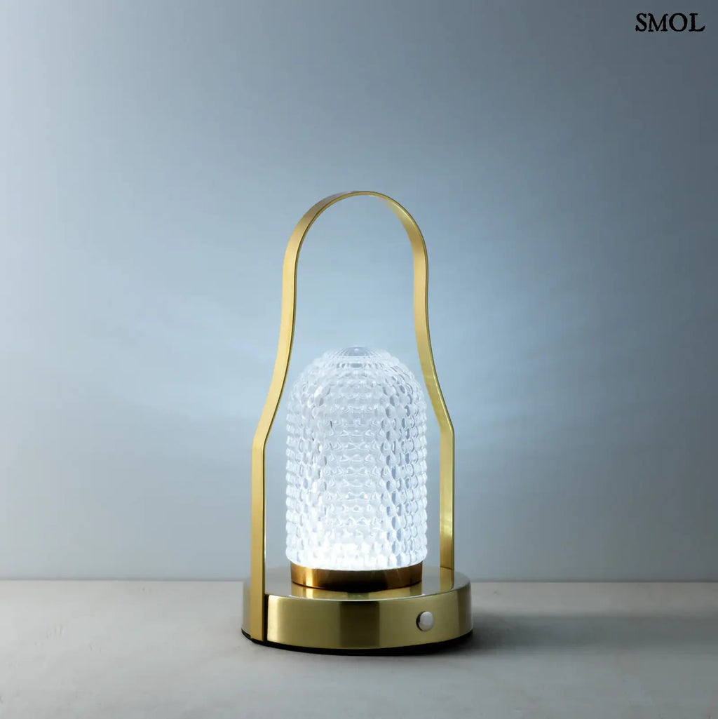 Hordozható LED asztali lámpa arany (brass) színű vázzal és fogantyúval, valamint texturált üveg búrával, kékes fénnyel