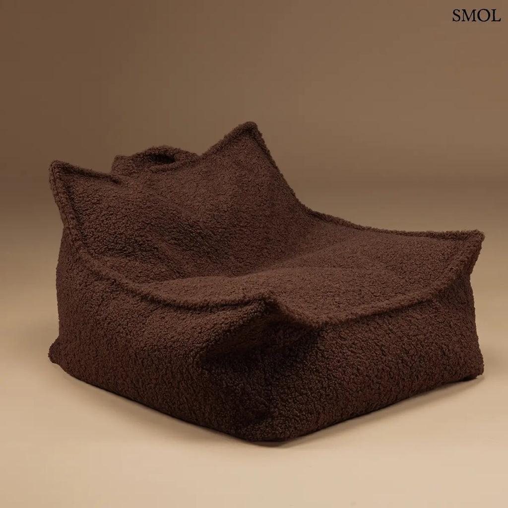 Prémium mogyoróbarna teddy anyagú babzsákfotel gyerekeknek, praktikus fogantyúval és kényelmes, stabil háttámlával, barna háttérrel