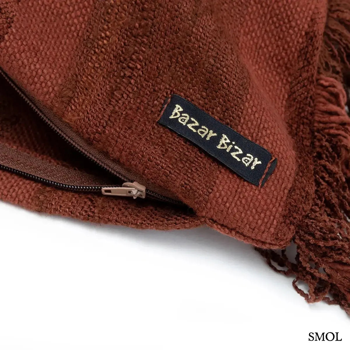 Hosszúkás bordó bársony díszpárnahuzat rojtokkal és csíkos textúrával, sarok nagyítva