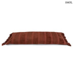 Hosszúkás bordó bársony díszpárnahuzat rojtokkal és csíkos textúrával, fektetve