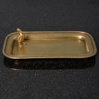 Antik arany sárgaréz dísztál ékszereknek, sarkában kis kacsa figurával, fekete háttérrel