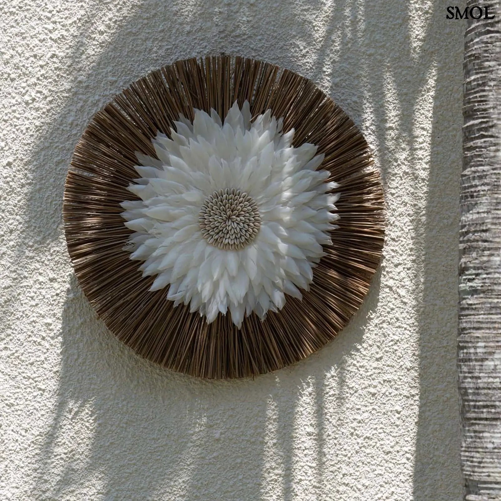 Fali dekoráció fehér tollakkal és kagylós középpel, natúr alang-alang fű alapon, falon