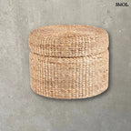 Kerek, fonott tároló puff natúr vízijácintból, zárt fedővel, szürke háttérrel