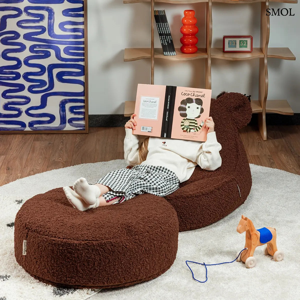 Barna színű, puha teddy anyagú gyerek babzsákfotel mackófülekkel, olvasó gyerekkel