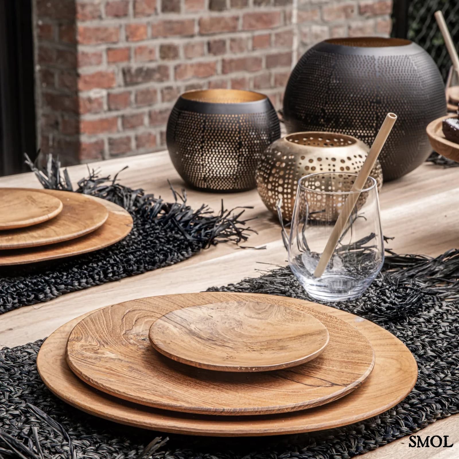 Gyertyatartó Pierced Ball, L méret, áttört réz, fekete-arany terített asztalon, fa tányérokkal