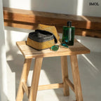 Arany színű, kézzel gyöngyözött tárolókosár bambusz alapból kisasztalon parfümmel