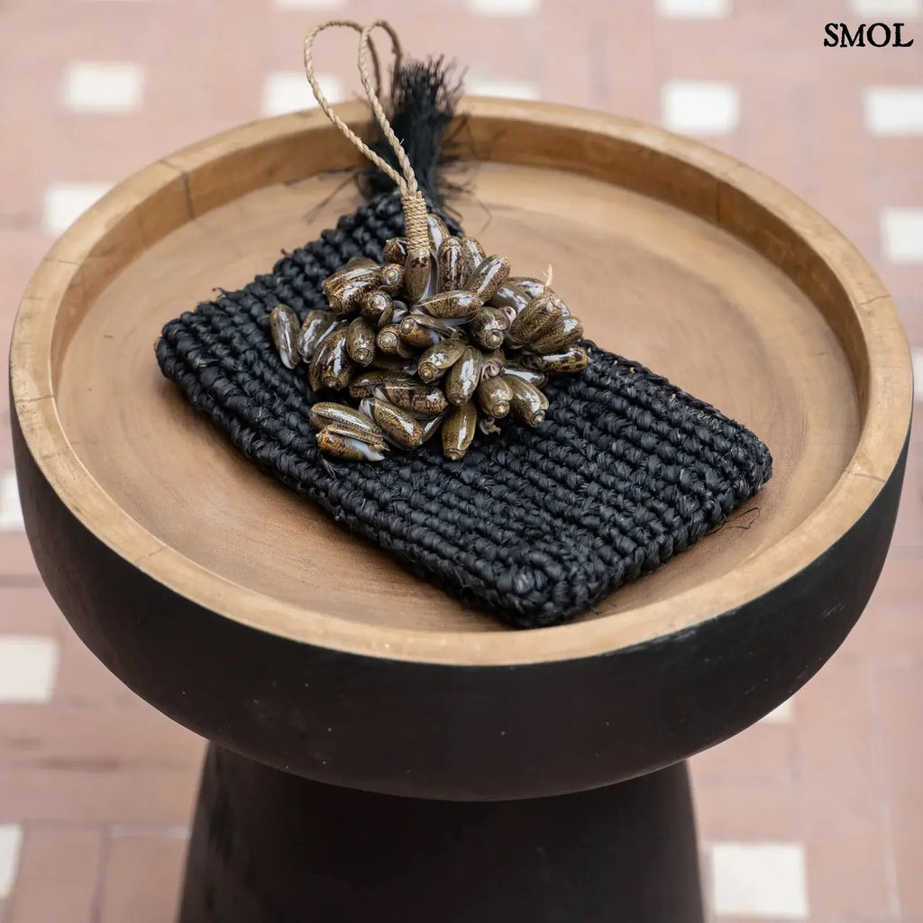 Barna kagyló függődísz, kézműves bojt formában, natúr kötélre akasztva kisasztalon