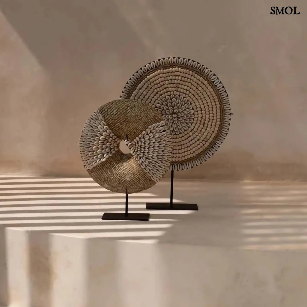 Natúr fehér kagylókból készült, kör alakú kagyló dekoráció fekete fémállvánnyal két méretben, mintával