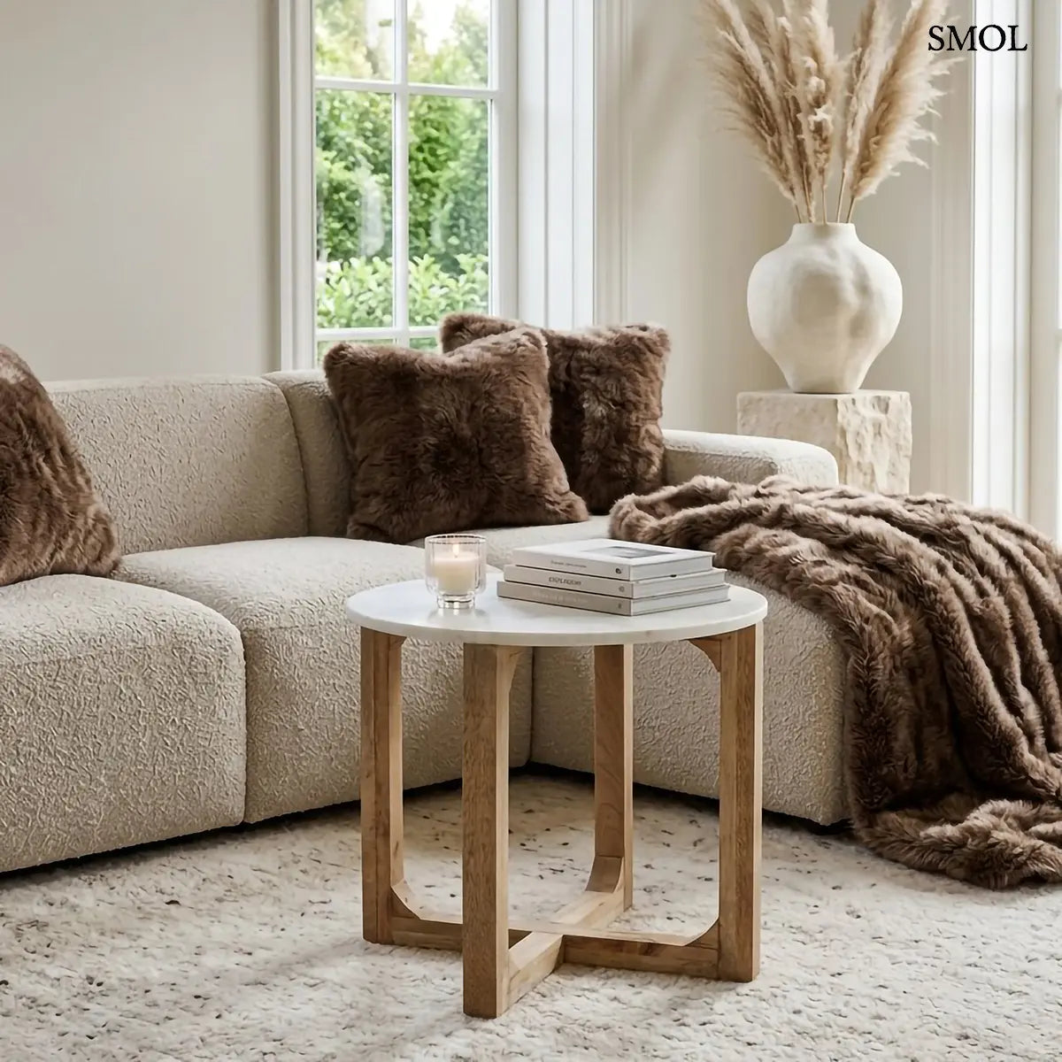MARBLE kerek kisasztal fehér márvány lappal és fa kereszttalppal – 50 × 50 cm, nappaliban könyvekkel és párnákkal