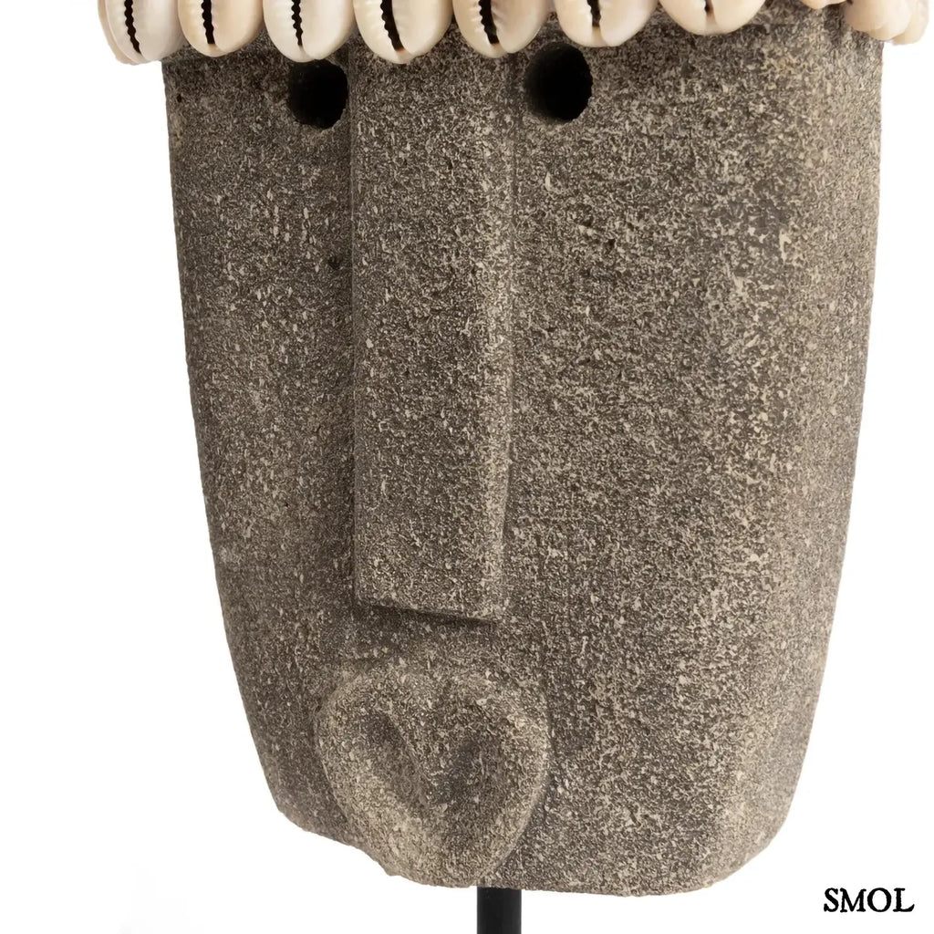 Kézzel faragott homokkő szobor kagylódíszekkel, fekete fém talapzaton, arc nagyítva