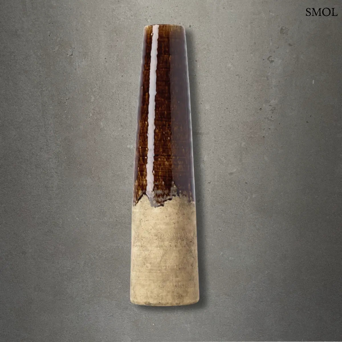 Betonbarna kőcserép kúpos váza szemcsés felülettel és sötét tónusokkal. Modern, minimalista dekorációs kiegészítő rusztikus textúrával, szürke háttérrel