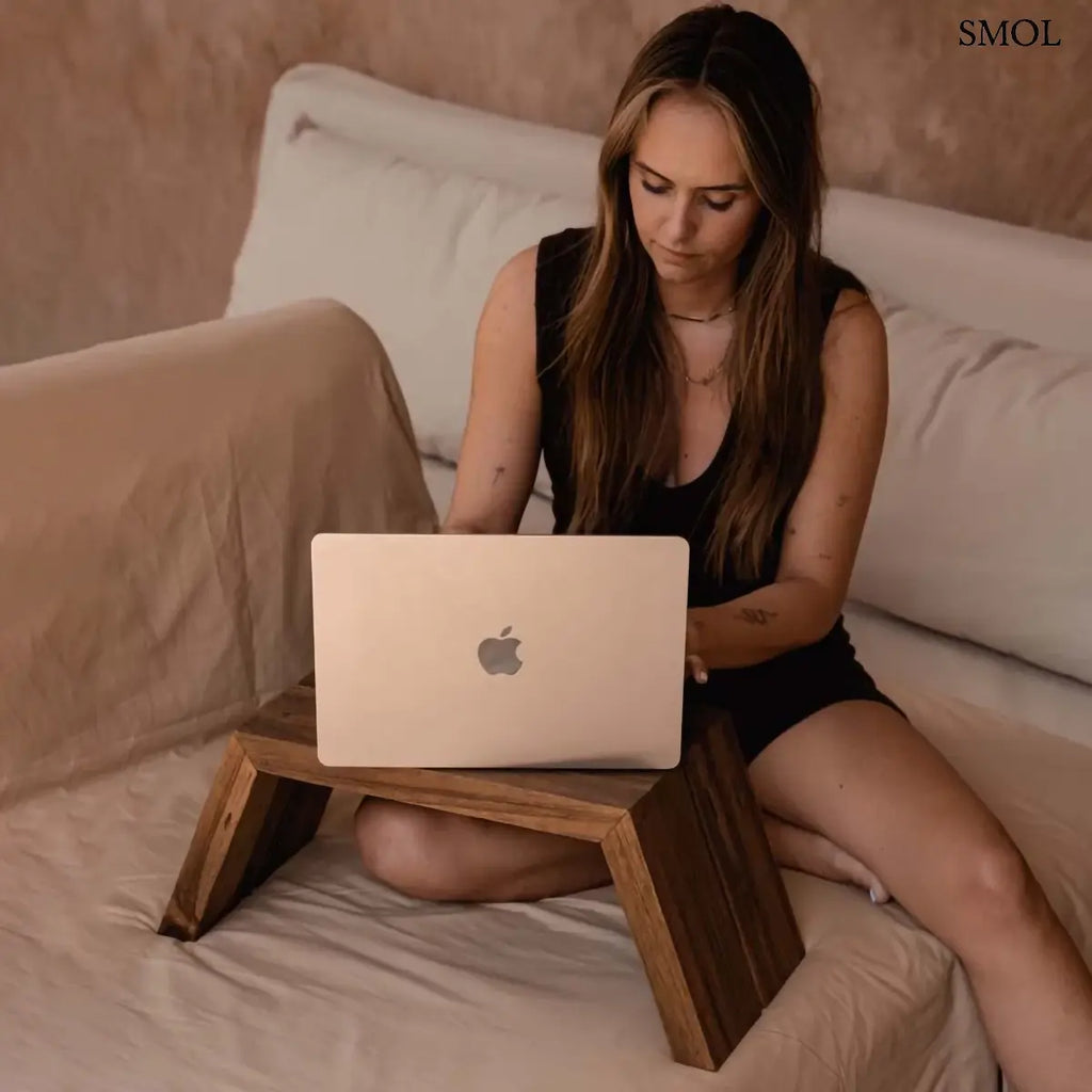 Tömör teakfa laptopasztal szögletes formával, natúr, 55×22 cm, nővel, ágyon laptoppal