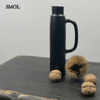 Modern fém váza és gyertyatartó matt fekete színben,  termésekkel