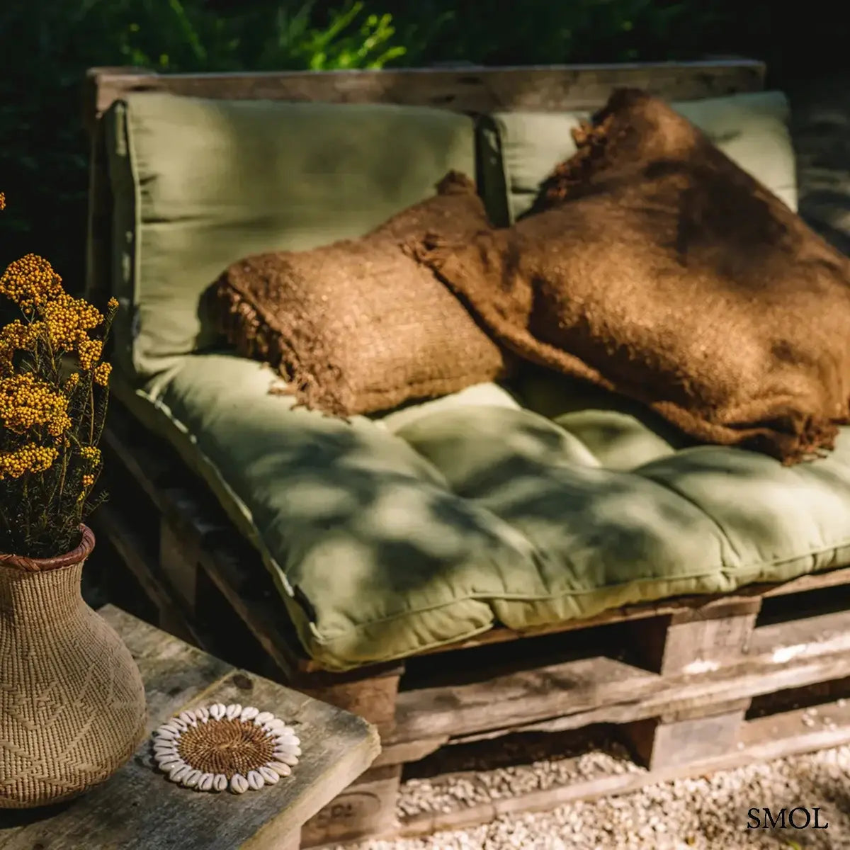 Négyzet alakú, sötétbarna pamut díszpárnahuzat rusztikus textúrával és kézzel rojtosított szélekkel, kanapén