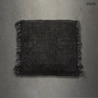 Éjfekete, rojtos szélű, rusztikus szövésű pamut díszpárnahuzat, szürke háttérrel