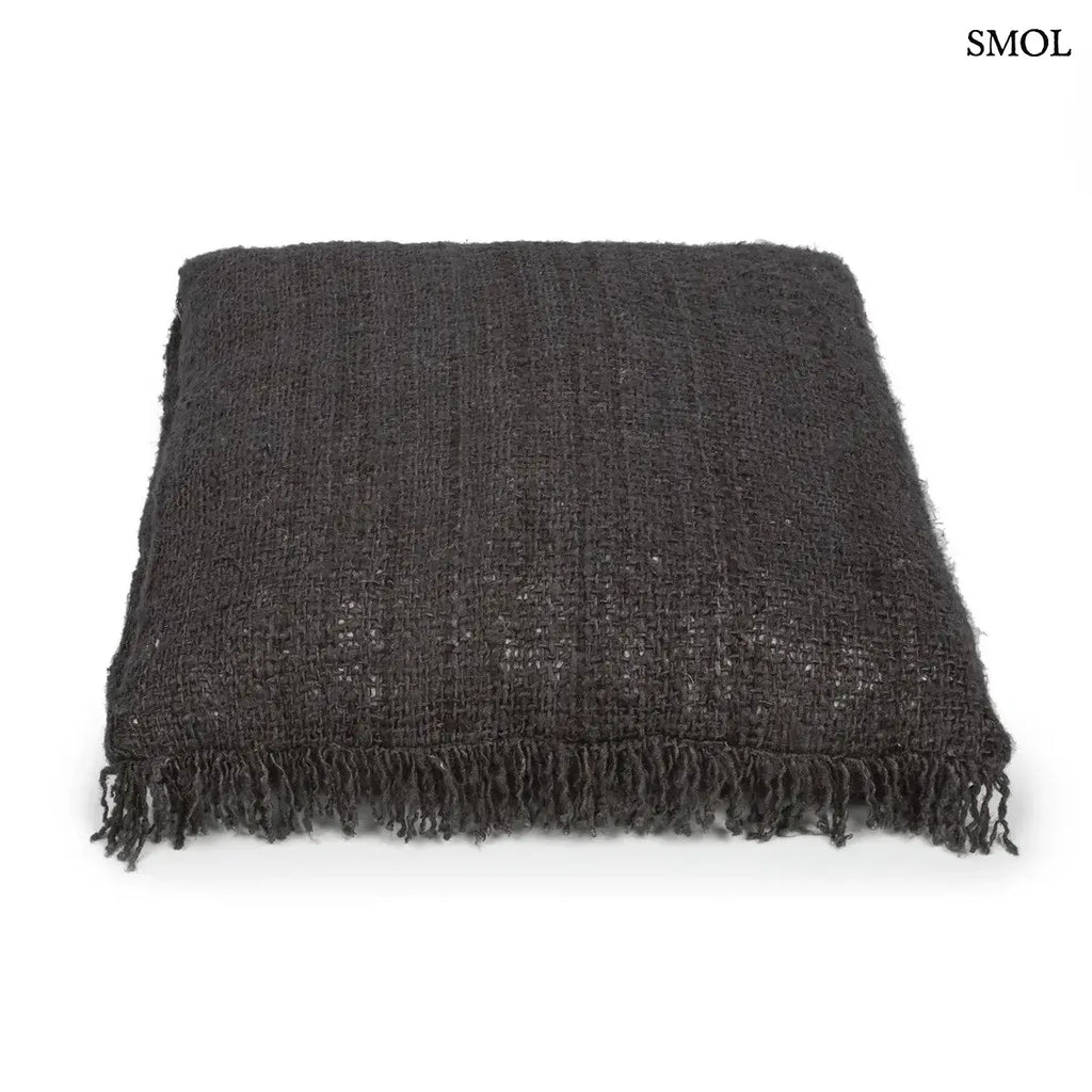 Éjfekete, rojtos szélű, rusztikus szövésű pamut díszpárnahuzat, fektetve