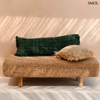 Hosszúkás, erdőzöld pamut díszpárnahuzat bohém rojtos szélekkel és rusztikus szövéssel, padon