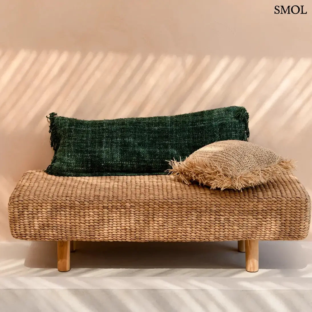 Hosszúkás, erdőzöld pamut díszpárnahuzat bohém rojtos szélekkel és rusztikus szövéssel, padon