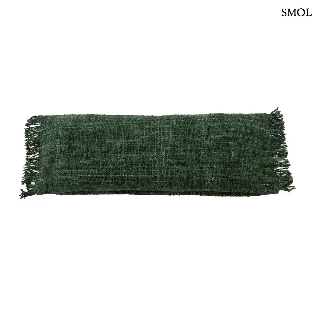 Hosszúkás, erdőzöld pamut díszpárnahuzat bohém rojtos szélekkel és rusztikus szövéssel, fehér háttérrel