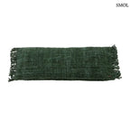 Hosszúkás, erdőzöld pamut díszpárnahuzat bohém rojtos szélekkel és rusztikus szövéssel, fehér háttérrel