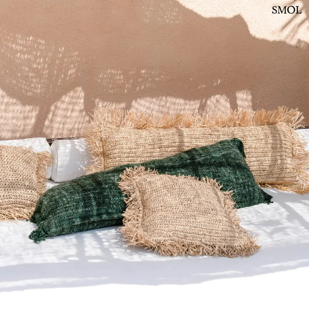Hosszúkás, erdőzöld pamut díszpárnahuzat bohém rojtos szélekkel és rusztikus szövéssel, natúr párnákkal