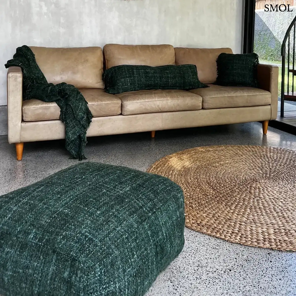 Hosszúkás, erdőzöld pamut díszpárnahuzat bohém rojtos szélekkel és rusztikus szövéssel, nappaliban, kanapén