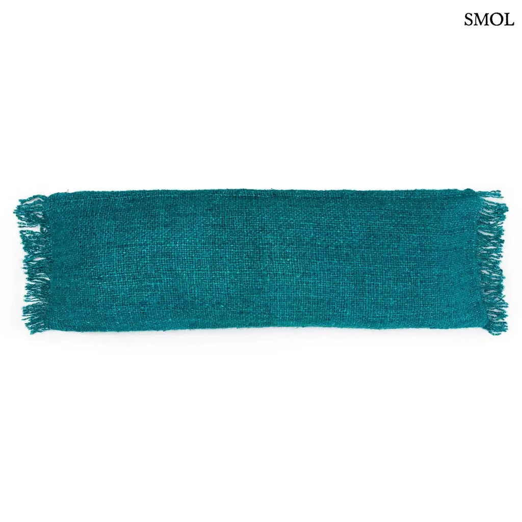 Hosszúkás, akvakék színű, rojtos szélű pamut díszpárnahuzat fehér háttérrel