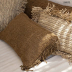 Rusztikus textúrájú barna pamut díszpárnahuzat bojtokkal, kézzel készült kivitelben, kanapén nagyítva