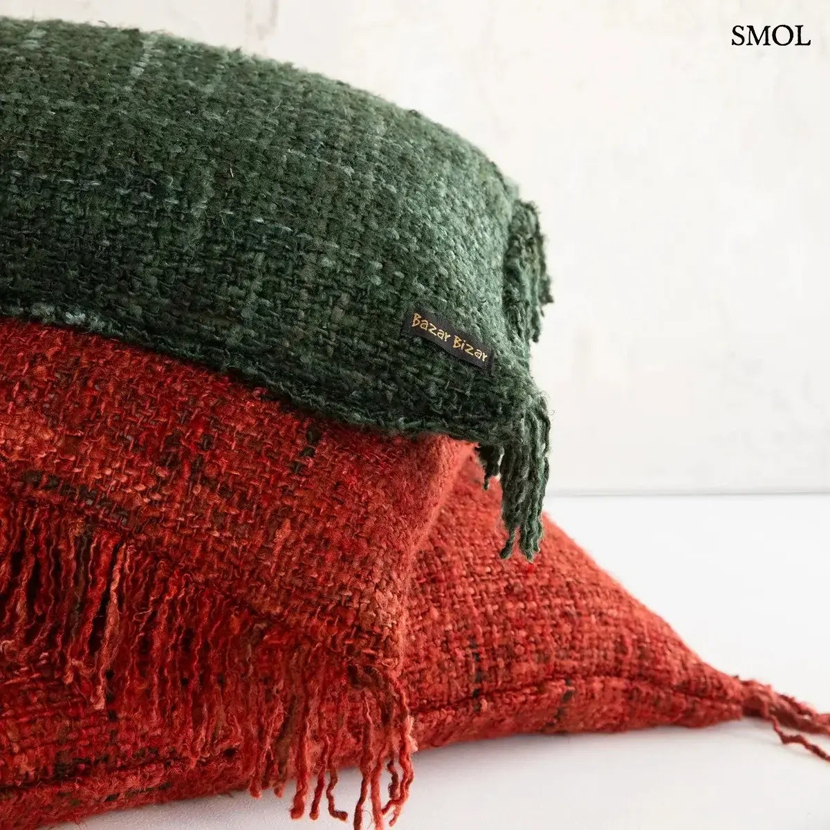 Bohém stílusú, kézzel szőtt cseresznyepiros pamut díszpárnahuzat rojtos szegéllyel, 60x60 cm-es méretben, egymáson zöld párnával