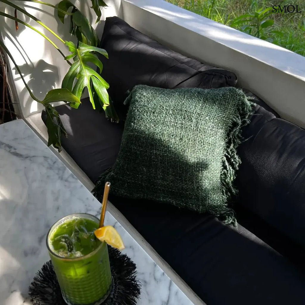 Erdőzöld, texturált pamut díszpárnahuzat rojtos szélekkel, kézzel szőtt bohém stílusban, teraszon, koktéllal