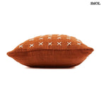 Pamut díszpárnahuzat, élénk terrakotta színben, sűrűn elhelyezett, kézzel varrott fehér kereszt mintákkal, fektetve