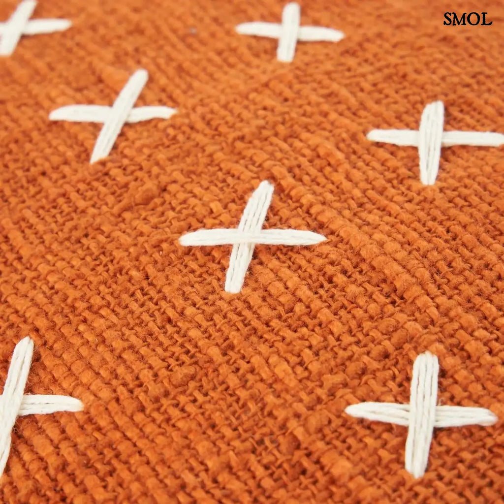 Pamut díszpárnahuzat, élénk terrakotta színben, sűrűn elhelyezett, kézzel varrott fehér kereszt mintákkal, nagyítva