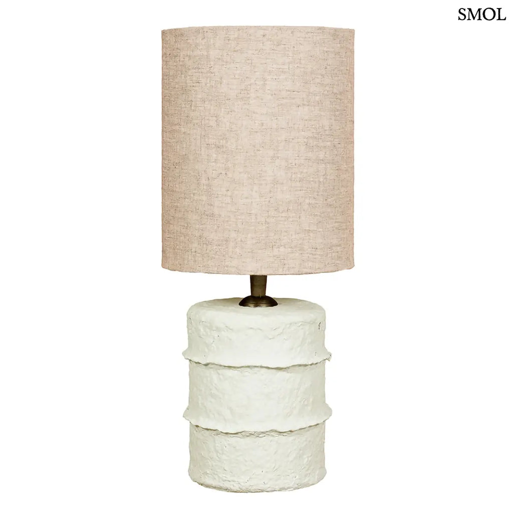 Rusztikus fehér papírmasé asztali lámpa hengeres natúr vászon lámpabúrával, fehér háttérrel