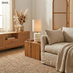 Rusztikus fehér papírmasé asztali lámpa hengeres natúr vászon lámpabúrával, nappaliban, lerakóasztalon