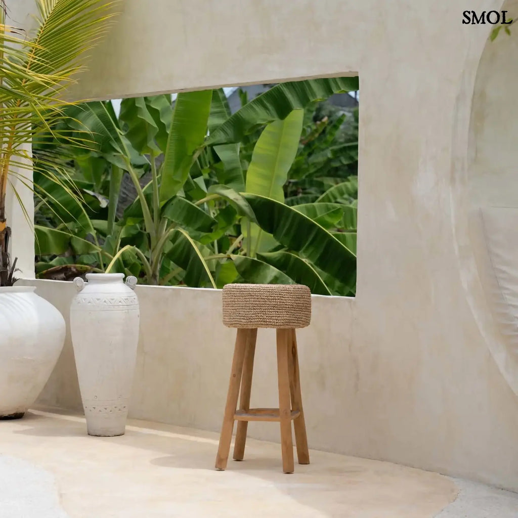 Raffia bárszék natúr színben, kézzel fonott ülőfelülettel és fa lábakkal, teraszon, növényekkel