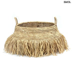 Raffia tárolókosár natúr színben, rojtos boho díszítéssel, fehér háttérrel