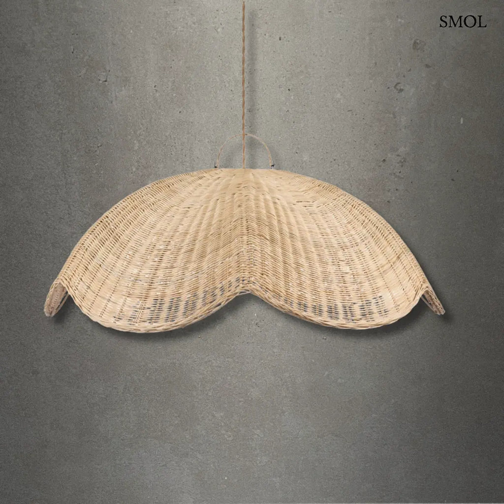 Rattan WAVE függőlámpabúra natúr színben, XL méretben. A hullám formájú, kézzel font rattanbúra juta kötélen lóg, oldalain enyhén felkunkorodó szélekkel, szürke háttérrel