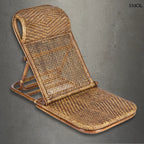 Ergonomikus kialakítású sötét dió rattan pihenőfotel, szürke háttérrel