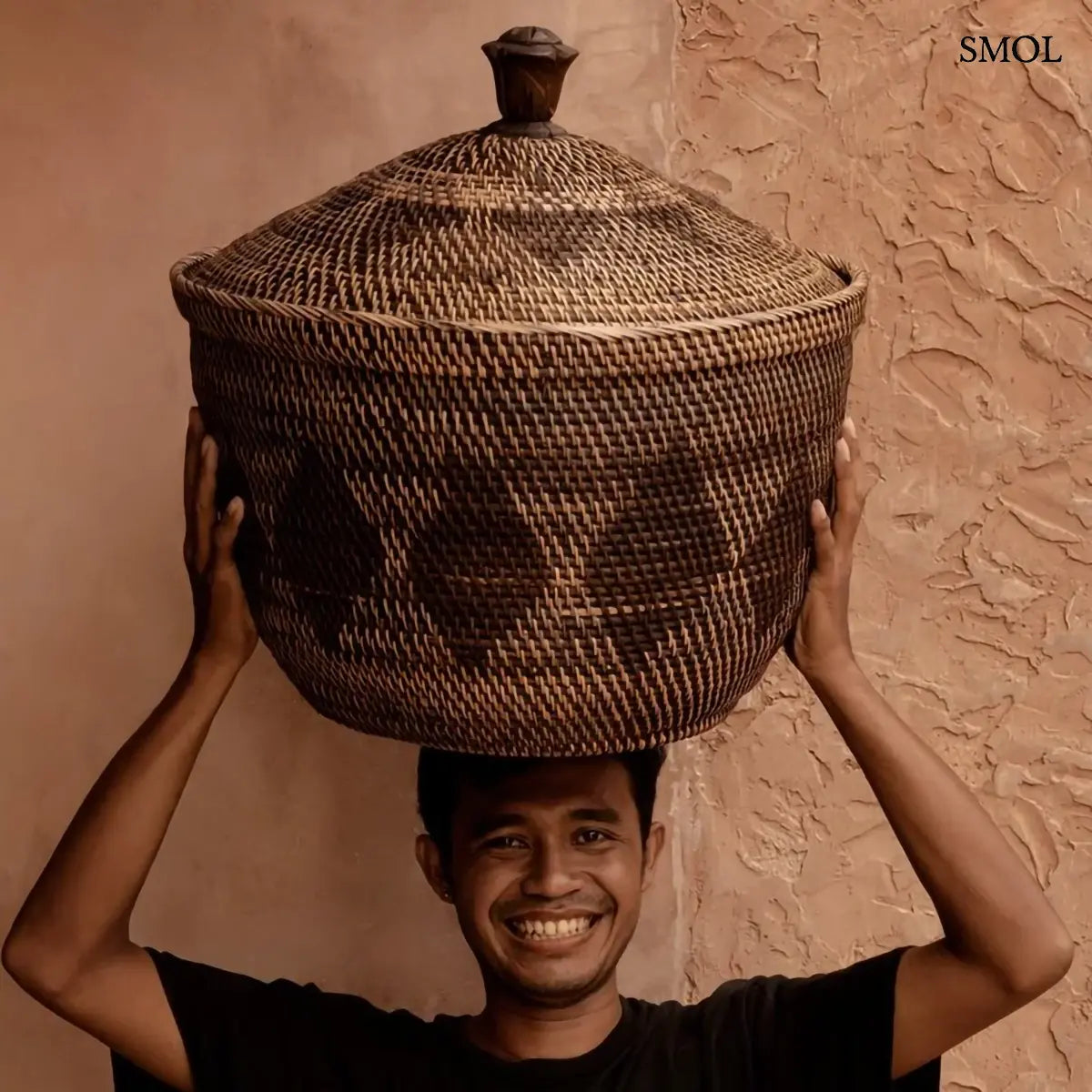 Natúr barna rattan tárolókosár fedővel és faragott fa fogantyúval, 55×52 cm, férfi fején